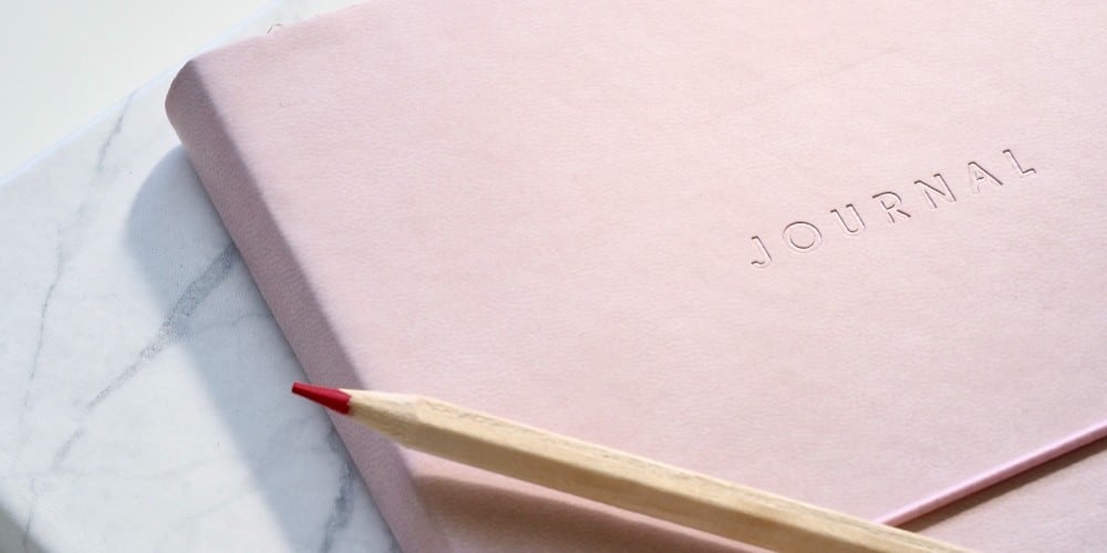 Een notitieboekje op de tafel met een potlood